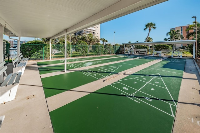 view of community featuring fence and shuffleboard