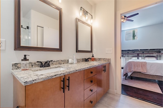 bathroom featuring ceiling fan, double vanity, a sink, and tile patterned floors