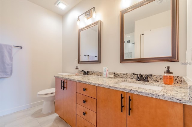 full bath with baseboards, a sink, toilet, and double vanity