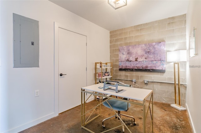 home office with concrete block wall, electric panel, and unfinished concrete flooring