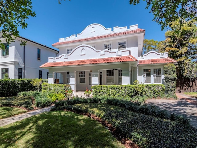 mediterranean / spanish house with stucco siding and a tiled roof