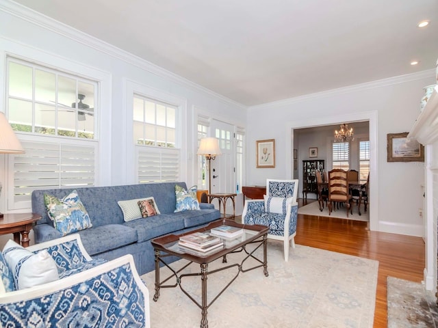 living room featuring wood finished floors, baseboards, recessed lighting, ornamental molding, and a chandelier