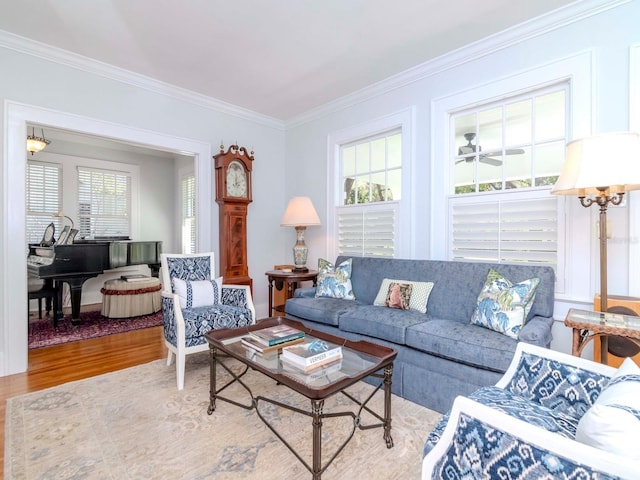 living room with a ceiling fan, crown molding, and wood finished floors