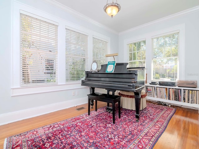 living area with visible vents, wood finished floors, and ornamental molding