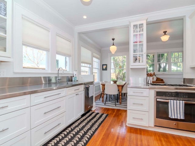 kitchen featuring a sink, stainless steel countertops, white cabinets, and stainless steel appliances