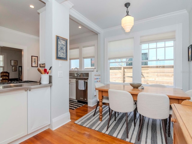 dining room with recessed lighting, light wood-type flooring, and crown molding