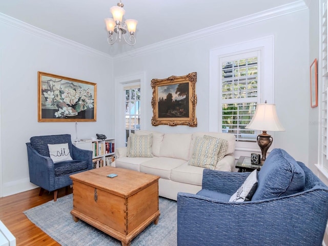 living room with crown molding, a notable chandelier, wood finished floors, and baseboards