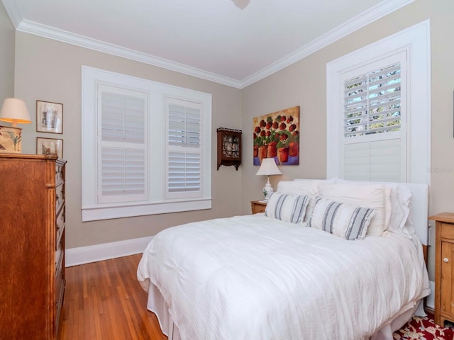 bedroom with baseboards, wood finished floors, and ornamental molding