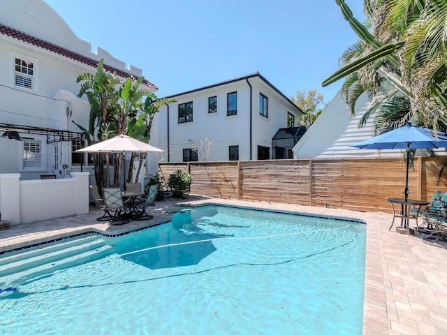 view of swimming pool with a patio area, a fenced in pool, and fence