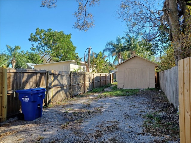 view of yard featuring an outbuilding, a storage unit, and a fenced backyard