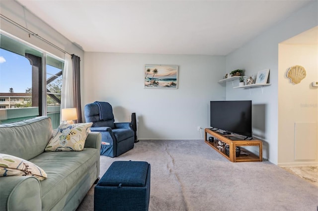 carpeted living room featuring baseboards