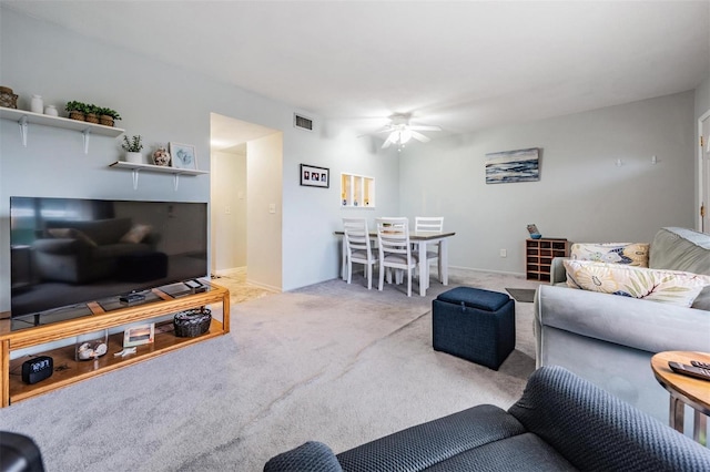 living area featuring carpet floors, visible vents, ceiling fan, and baseboards