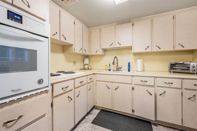 kitchen featuring light countertops, white appliances, a toaster, and a sink