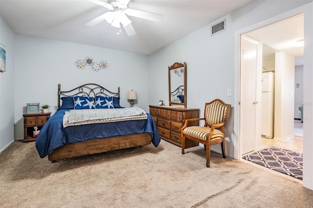 bedroom featuring freestanding refrigerator, carpet floors, visible vents, and a ceiling fan