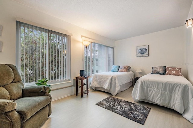 bedroom with baseboards and wood finished floors