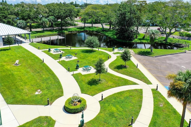 view of property's community with a lawn and a water view