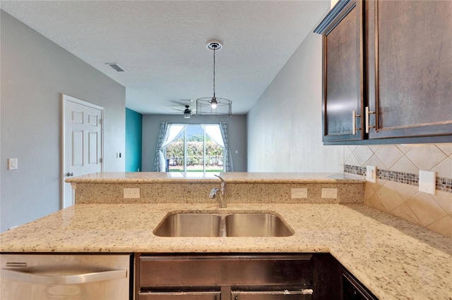 kitchen featuring decorative backsplash, a sink, visible vents, and light stone countertops