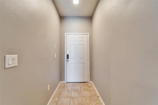 entryway with light tile patterned floors and baseboards