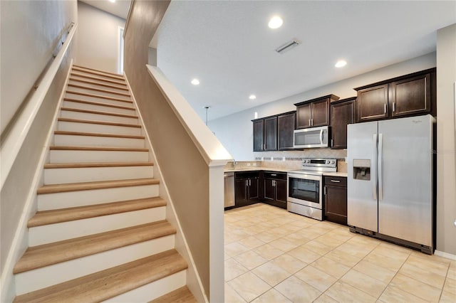 kitchen with dark brown cabinetry, recessed lighting, stainless steel appliances, light countertops, and decorative backsplash