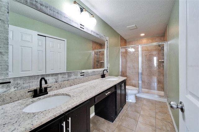 full bathroom with toilet, a stall shower, a textured ceiling, and a sink