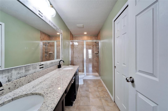 full bath featuring toilet, a sink, a shower stall, tile patterned floors, and double vanity