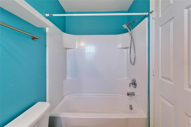 full bathroom with a textured ceiling, shower / bath combination, and toilet