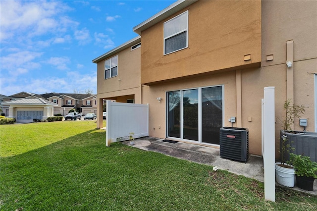 back of property featuring central air condition unit, a yard, and stucco siding