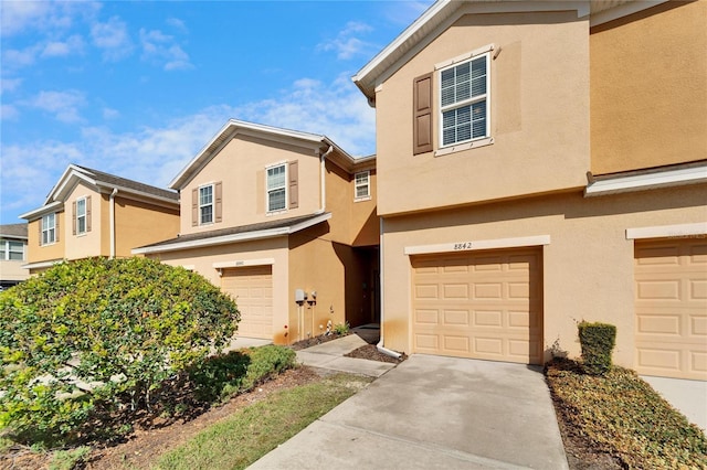 view of front facade with driveway, an attached garage, and stucco siding