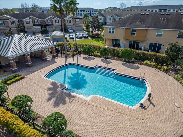 pool featuring a residential view, fence, and a patio