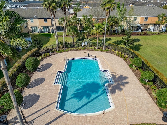 community pool featuring a residential view, fence, a patio, and a yard