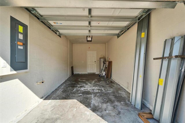 garage with concrete block wall, gas water heater, and electric panel