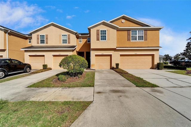 view of front of house featuring a garage, driveway, and stucco siding