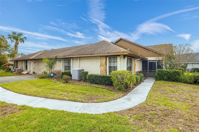 view of side of home with driveway, central AC unit, a lawn, an attached garage, and stucco siding