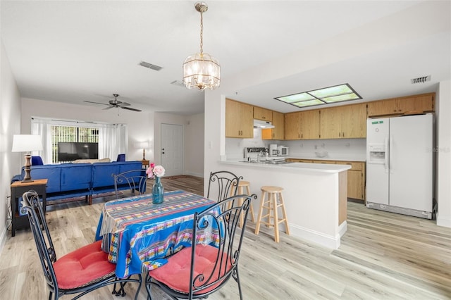 dining area featuring light wood-style floors and visible vents