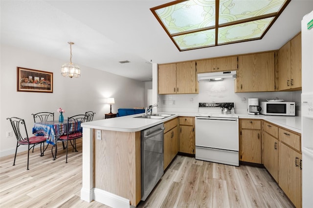 kitchen with white appliances, light countertops, a sink, and under cabinet range hood