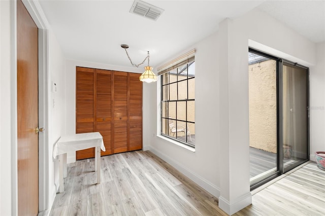 interior space with light wood-style flooring, visible vents, and baseboards