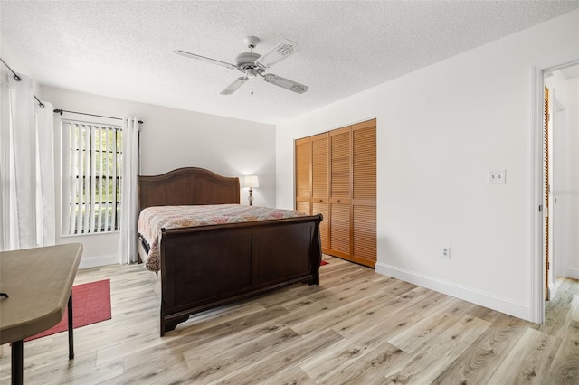 bedroom featuring light wood-type flooring, a closet, and baseboards