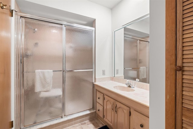 bathroom featuring a shower with door, a closet, and vanity