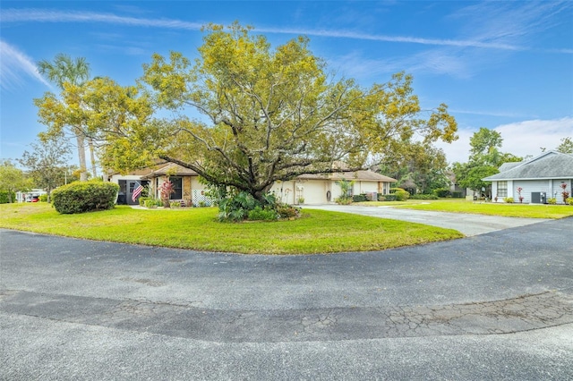 view of front of home featuring a garage, a front yard, and concrete driveway