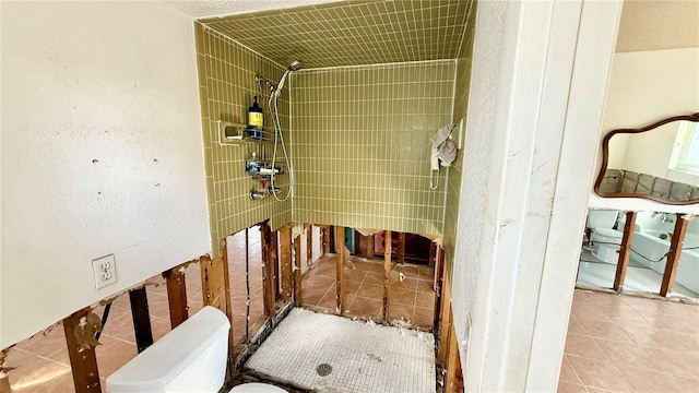 bathroom featuring a shower stall, toilet, and tile patterned floors