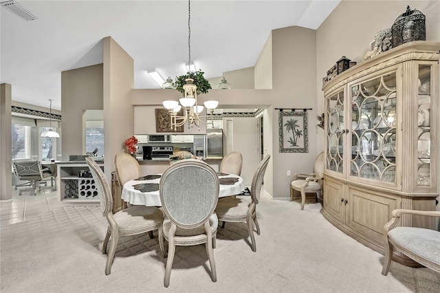 dining space with light carpet, high vaulted ceiling, visible vents, and a notable chandelier