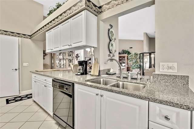 kitchen featuring dishwasher, light stone counters, a sink, and white cabinetry