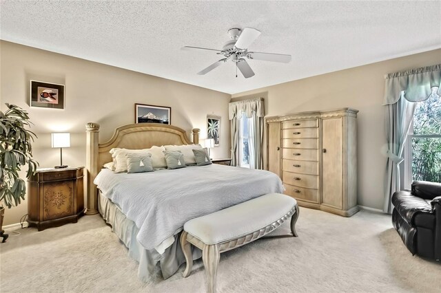 bedroom featuring ceiling fan, baseboards, a textured ceiling, and light colored carpet