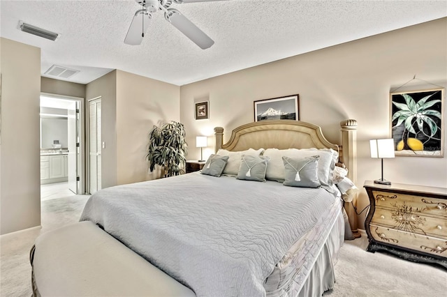 bedroom with ensuite bathroom, carpet, and visible vents