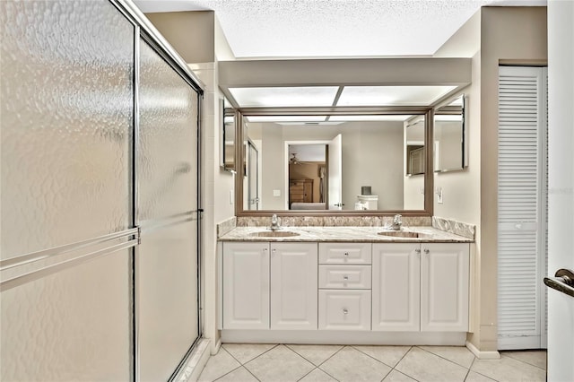 full bath featuring a stall shower, a sink, and tile patterned floors