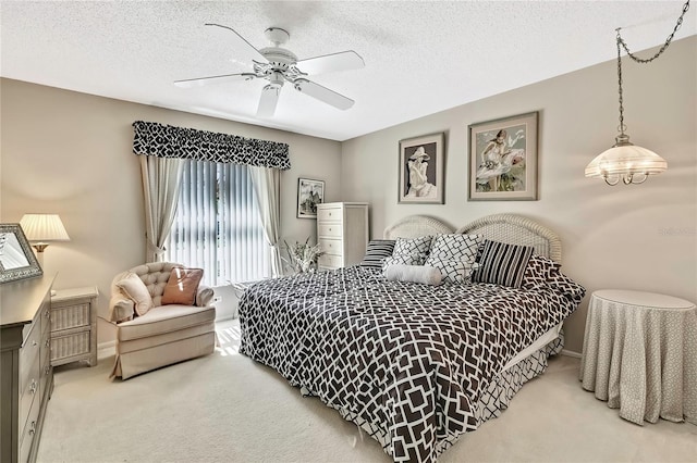 bedroom with a textured ceiling, carpet floors, a ceiling fan, and baseboards