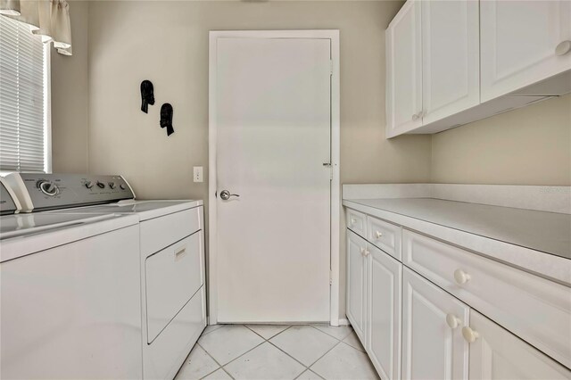 laundry room featuring light tile patterned flooring, cabinet space, and washer and clothes dryer