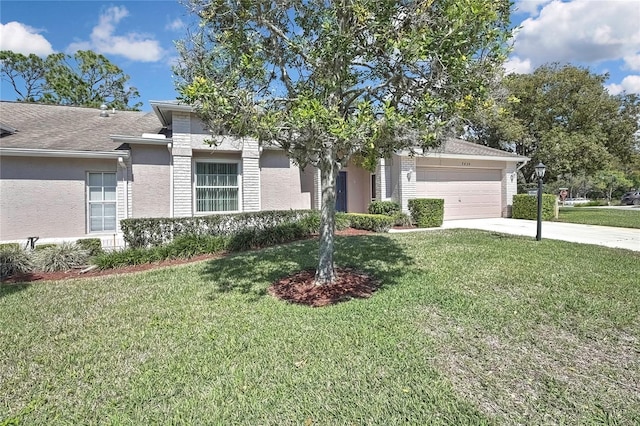 single story home with driveway, an attached garage, a front lawn, and stucco siding