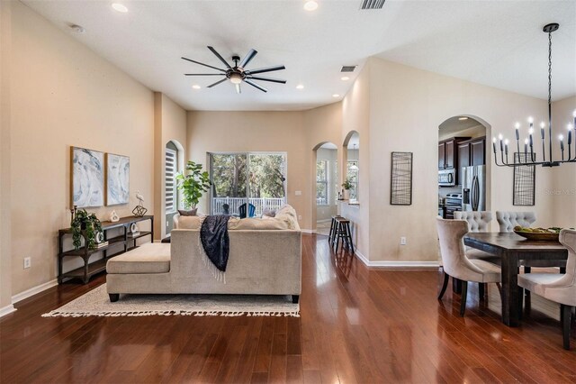 living room with baseboards, a chandelier, and dark wood-type flooring