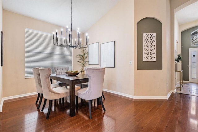 dining area with a chandelier, high vaulted ceiling, dark wood finished floors, and baseboards